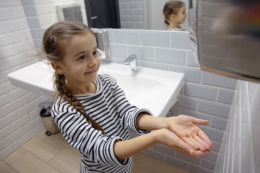 Girl drying hands under a  Hand Dryers